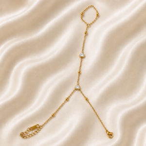 Crystal heart gold hand chain bracelet on satin background