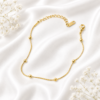 Gold-tone stainless steel anklet with delicate bead accents and an adjustable chain.