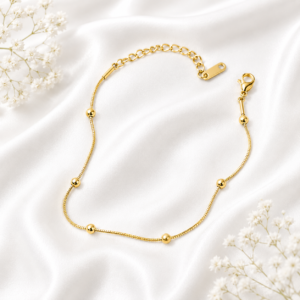 Gold-tone stainless steel anklet with delicate bead accents and an adjustable chain.