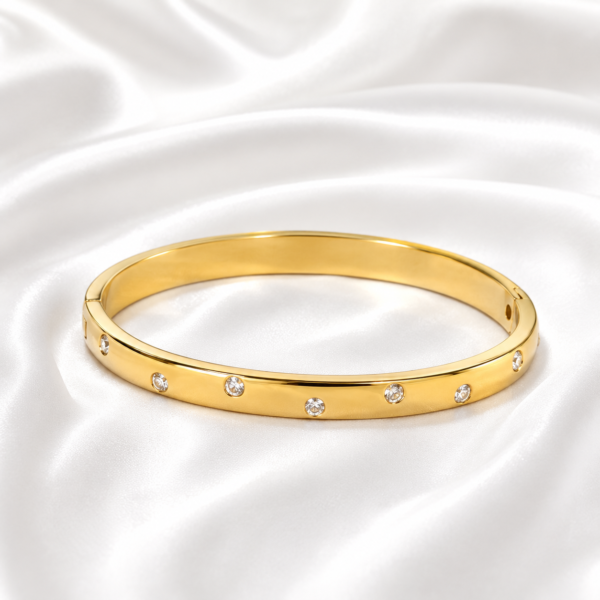 Classic gold crystal bangle on white satin background