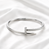Silver crystal nail bangle on white satin background