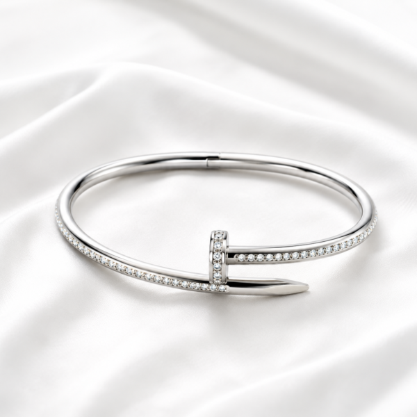 Silver crystal nail bangle on white satin background
