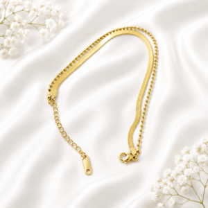 Luxury dual-chain gold bracelet with snake chain and bead chain displayed on a white satin background