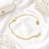 Minimal gold stainless steel bracelet with polished heart charm displayed on a white satin background