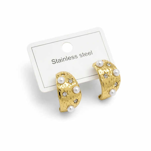 Gold-tone textured stainless steel hoop earrings featuring pearl accents and sparkling crystals displayed on a jewelry card.