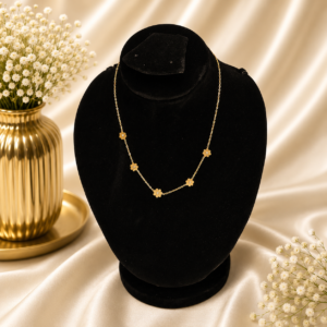 Gold stainless steel floral charm necklace displayed on a black velvet jewelry stand.