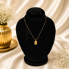 Gold stainless steel botanical pendant necklace displayed on a black velvet jewelry stand.