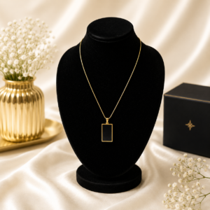 Gold stainless steel necklace with a black rectangle pendant displayed on a black velvet jewelry stand.