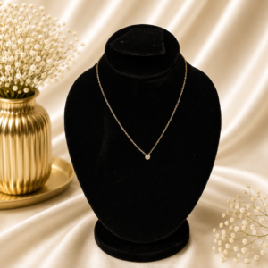Gold stainless steel solitaire crystal necklace displayed on a black velvet jewelry stand.