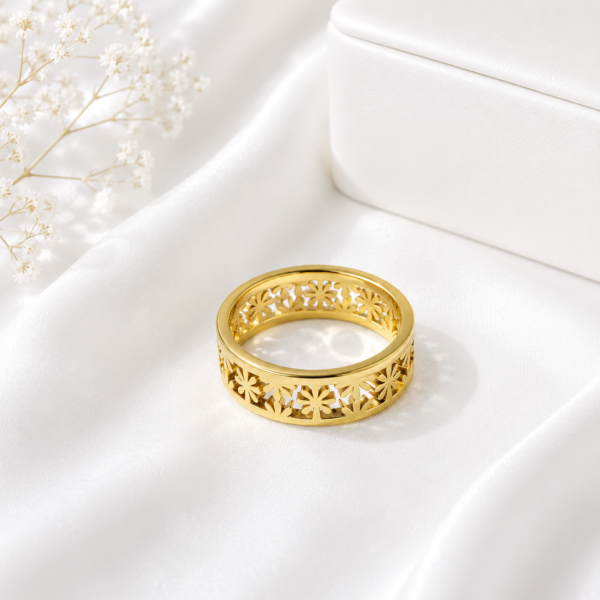 Gold stainless steel floral cutout band ring displayed on a white satin background.