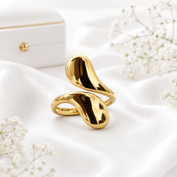 Gold stainless steel wave statement ring displayed on a white satin background.